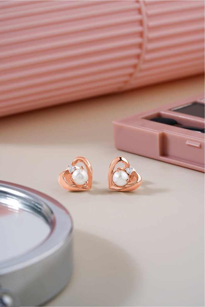 Stylish heart-shaped gold earrings featuring pearls and diamonds, perfect for a luxurious look.