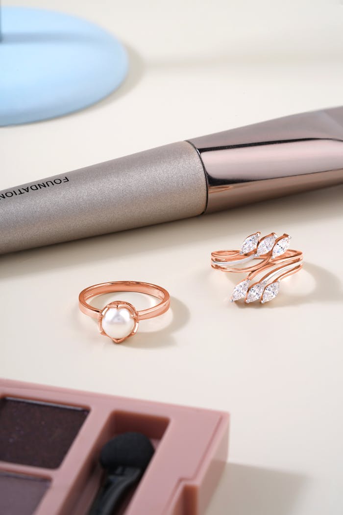 contact-img A chic display of pearl and diamond rings with makeup accessories.